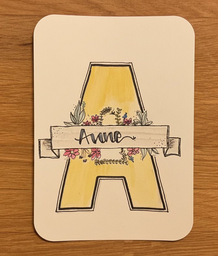Personalisierte Namenskarte mit floralem Initial und Handlettering